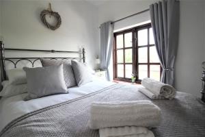a bedroom with a white bed with towels on it at Jasmine Cottage, Buxton Norfolk, Sleeps 4 in Norwich