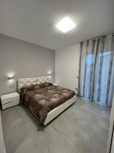 a bedroom with a bed and a large window at La Casa Di Lilla in Tortoreto Lido