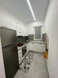 a kitchen with a black refrigerator and white cabinets at La Casa Di Lilla in Tortoreto Lido