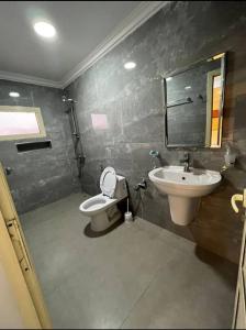 y baño con lavabo, aseo y espejo. en فندق أباهى3, en Al Hofuf