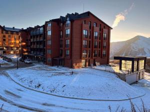 a building in the snow in front of a mountain at New Gudauri, Alpic, Gudauri in Gudauri