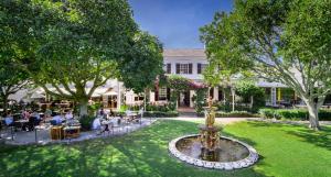 a garden with a fountain in front of a building at Vineyard Hotel in Cape Town