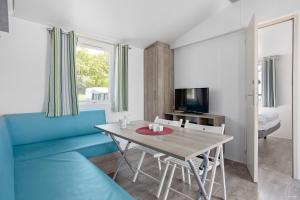 sala de estar con mesa y sofá azul en First Camp Ekerum - Öland en Borgholm