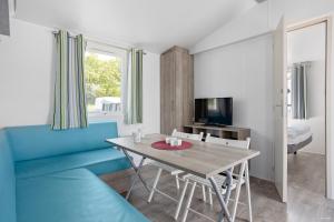 a living room with a table and a blue couch at First Camp Ekerum - Öland in Borgholm