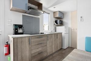 a kitchen with wooden cabinets and a white refrigerator at First Camp Ekerum - Öland in Borgholm