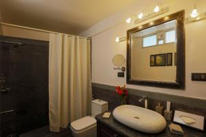 a bathroom with a sink and a toilet and a mirror at Heritage View in Ooty