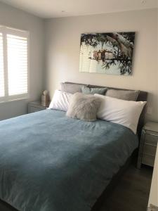 1 dormitorio con 1 cama con edredón azul en The Beach Box, en Broadwater
