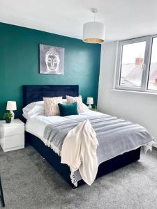 una camera con un letto con una parete blu di Great location, spacious 3 bedroom house a Pallion