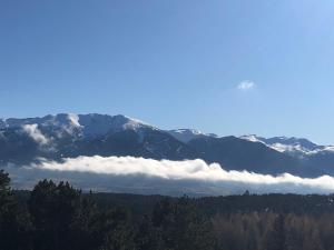 śnieżna góra z chmurami na pierwszym planie w obiekcie Studio cabine w mieście Bolquere Pyrenees 2000