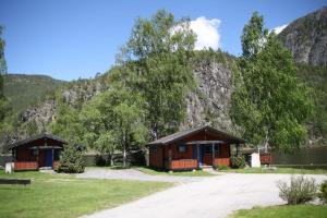 a couple of cabins in front of a mountain at Sølvgarden Cottages in Rysstad