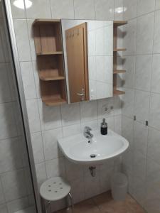 a bathroom with a sink and a mirror and a toilet at Romantik Appartements in Sankt Englmar