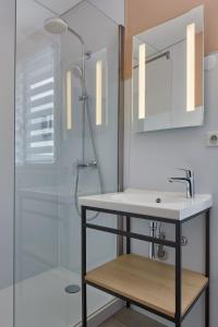 a bathroom with a sink and a shower at Maison Cabotte in Beaune