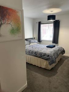 una camera da letto con un letto e un quadro sul muro di Large 2 bedroom apartment, 4 beds one 1 en-suite, Free parking Nr Chelt Elmore and Quays a Gloucester
