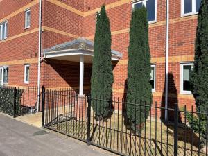 a group of trees in front of a brick building at Large 2 bedroom apartment, 4 beds one 1 en-suite, Free parking Nr Chelt Elmore and Quays in Gloucester
