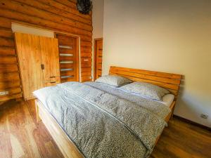 a bedroom with a bed and a wooden door at Koliba Pod Skalami in Súľov-Hradná