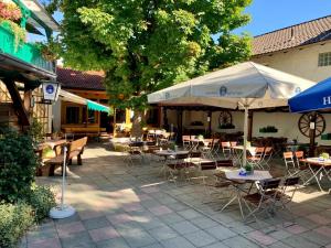 an outdoor patio with tables and chairs and umbrellas at Landgasthof Böck in Unterbrunn
