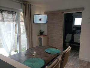 a dining room with a table and a television on the wall at Loue gîte de campagne 