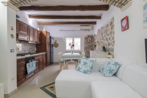 Loceri的住宿－Casa Vacanza Il Murales，一间带白色沙发的客厅和一间厨房