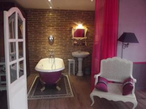 La salle de bains est pourvue d'une baignoire et d'un lavabo. dans l'établissement La Chaussee d'Olivet en Mayenne, à Olivet