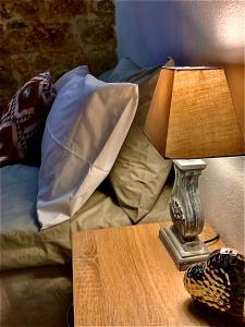 un tavolo con una lampada sopra un letto di Sterna a Mesovounion-Zagori