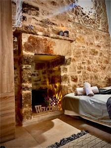 a bedroom with a stone wall with a fireplace at Sterna in Mesovounion-Zagori