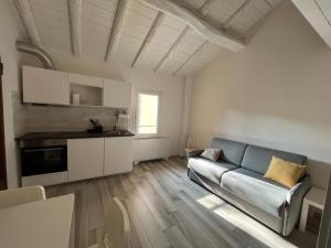 a living room with a couch and a kitchen at Terrazza Montegrappa in Reggio Emilia