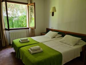 Un dormitorio con dos camas con sábanas verdes y una ventana. en Apartamentos Osa Menor, en Cala d´Or 34 fotos más