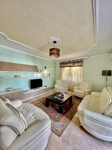 ein Wohnzimmer mit 2 weißen Sofas und einem TV in der Unterkunft Apartment in Durres Elio in Golem