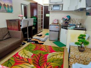 a living room with a couch and a kitchen at One Bedroom Apartment at Avida Tower 2 in Iloilo City