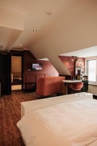 1 dormitorio con cama, mesa y cocina en Hotel & Spa Savarin - Rijswijk, The Hague en Rijswijk