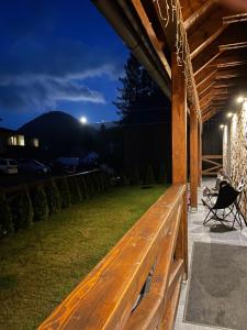 una panca di legno su un patio di notte di Domicil Donky a Donovaly