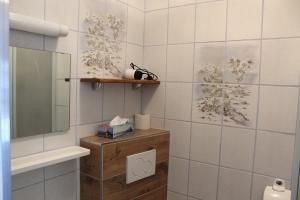 ein Bad mit weiß gefliesten Wänden und einem Spiegel in der Unterkunft Gasthaus Zur Waldesruh in Waffenbrunn