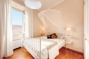sypialnia z białym łóżkiem i oknem w obiekcie Elegant Apartment Behind the Colosseum w Rzymie