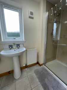 a bathroom with a sink and a shower at Allanvale Holiday Home in Inverness