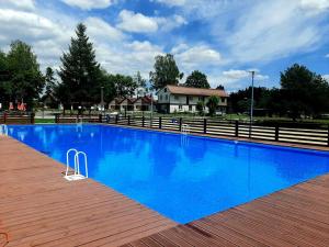 ein großer blauer Pool mit einem Zaun um ihn herum in der Unterkunft Miejsko Gminny Ośrodek Sportu i Rekreacji in Łopuszno