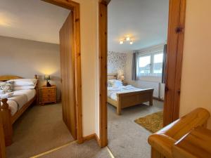 a room with a bedroom with a bed and a mirror at Allanvale Holiday Home in Inverness