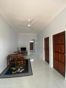 een woonkamer met een tafel en een plafondventilator bij Tok Mek Homestay in Setiu