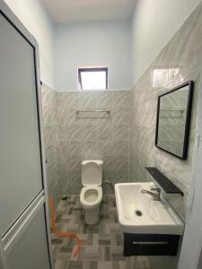 a bathroom with a white toilet and a sink at Tok Mek Homestay in Setiu