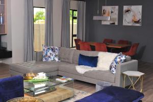 sala de estar con sofá y mesa en Square Connexions Guest House, en Gaborone