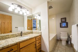 a bathroom with a sink and a toilet and a mirror at Big Cottonwood 2 Bedroom Brighton Chalet in Brighton +52 photos
