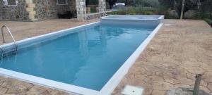a swimming pool with blue water in a backyard at Sunny Countryside Villa - With private pool in Faliraki