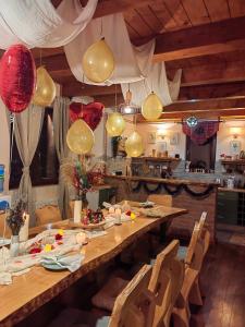 a dining room with a long wooden table with balloons at Rustic dream MIA in Zlatibor