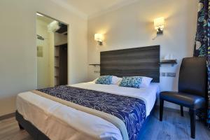 une chambre d'hôtel avec un lit et une chaise dans l'établissement Hotel Cayrons Vence & St Paul de Vence, à Vence