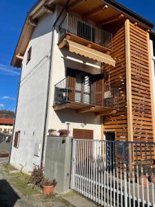een wit huis met een balkon en een hek bij Camera con vista Castello in Pavone Canavese