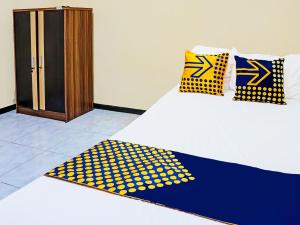 a bed with yellow and blue polka dot pillows on it at OYO Life 92091 Citra Omah Syariah in Blimbing