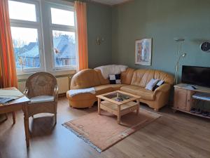 uma sala de estar com um sofá e uma mesa em Pension Villa Immergrün em Oberhof