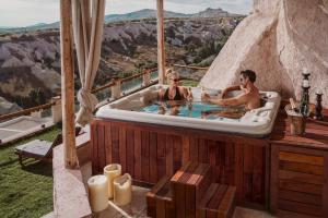 two people in a jacuzzi tub with a view at Taskonaklar in Uchisar
