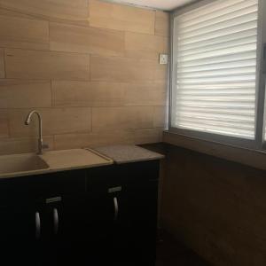 uma cozinha com um lavatório e uma janela com persianas em HPLagos em Lagos