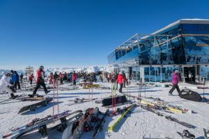 a group of people standing in the snow next to a ski lodge at Hotel Rosanna by Alpeffect Hotels in Sankt Anton am Arlberg