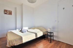 Schlafzimmer mit einem Bett und einem Beistelltisch in der Unterkunft Le Lutetia - 4pers - Au Calme et lumieux - Wifi - Proche Gare in Toulon